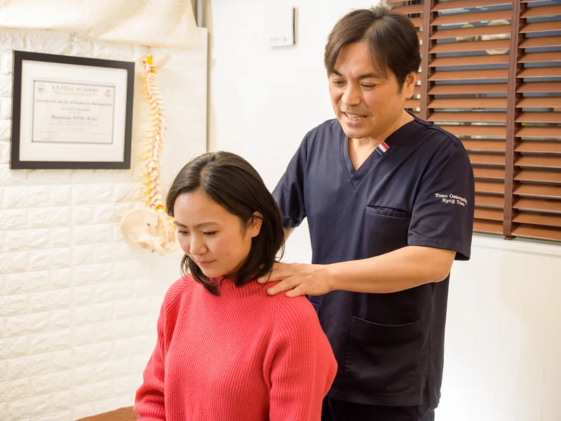 立った姿勢で、肩と背中の状態を後ろから確認しているところ